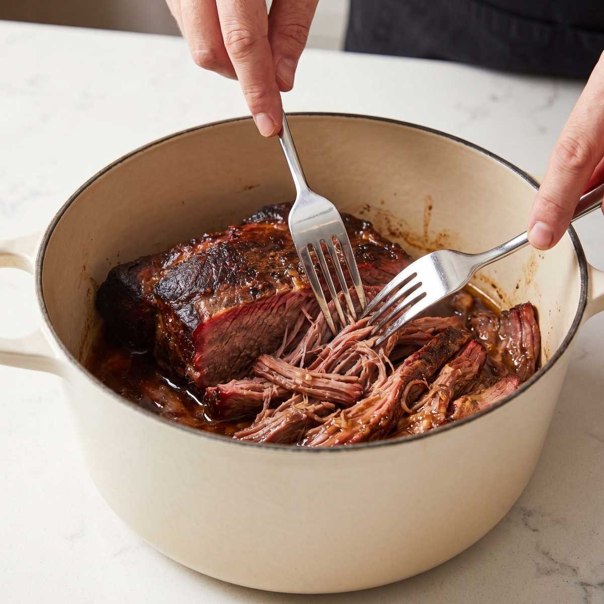 shredding-tender-smoked-mississippi-pot-roast-beef-with-two-forks-in-a-dutch-oven