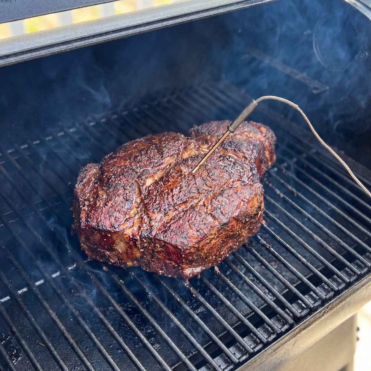 smoking-unwrapped-beef-chuck-roast-with-a-temperature-probe-on-a-pellet-grill-grate