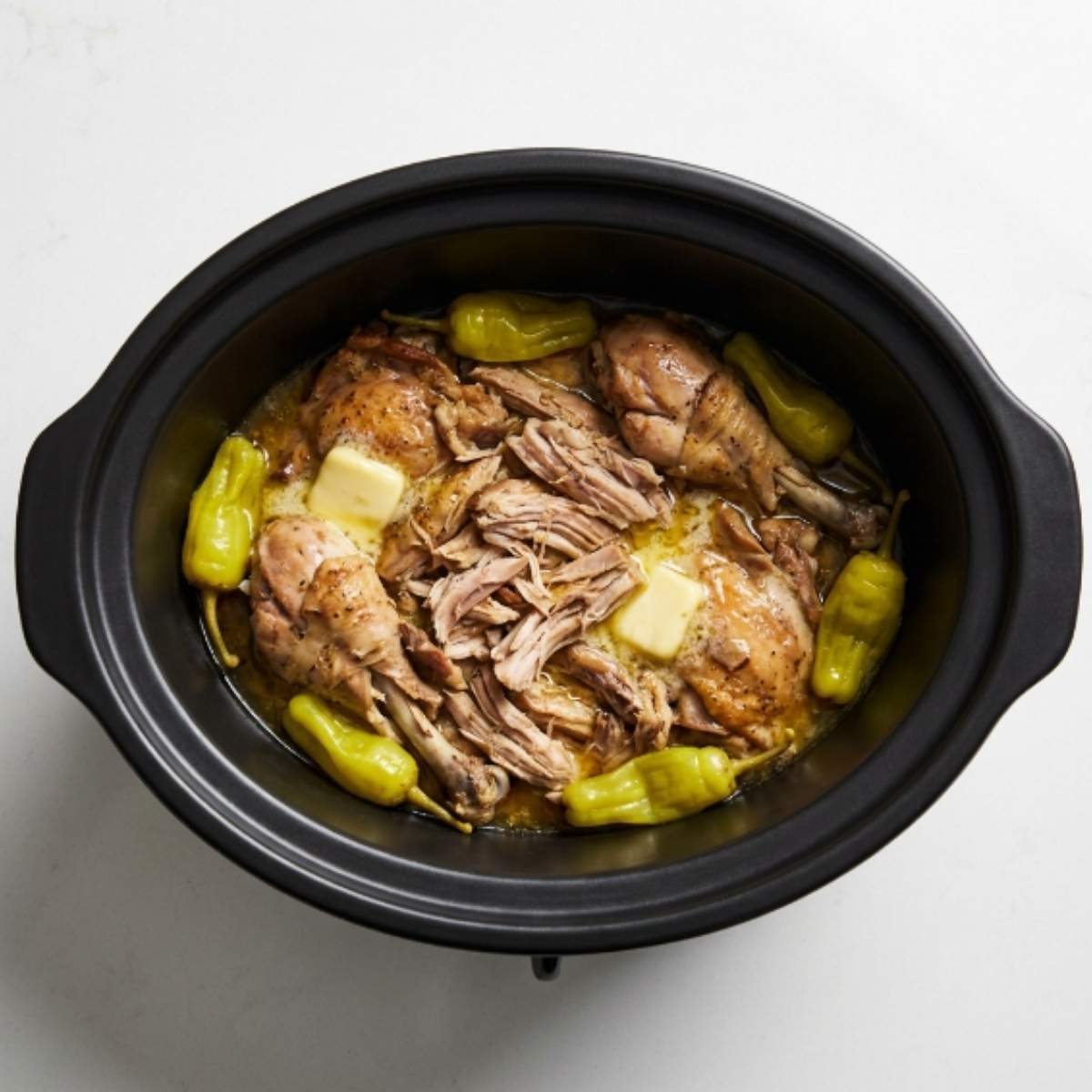 chicken mississippi pot roast in a slow cooker with pepperoncini and butter