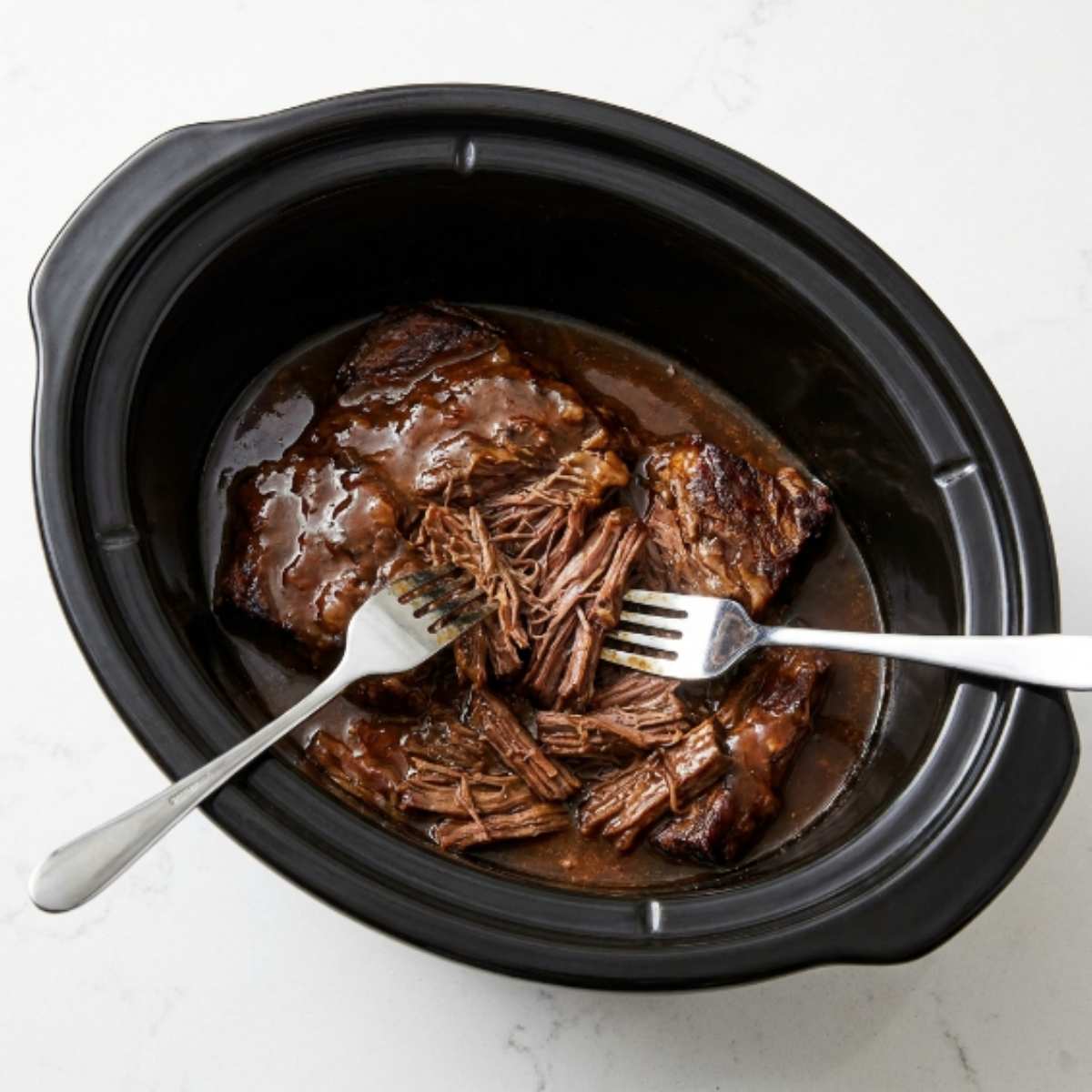 shredding-cooked-tender-mississippi-pot-roast-with-two-forks-in-a-crockpot