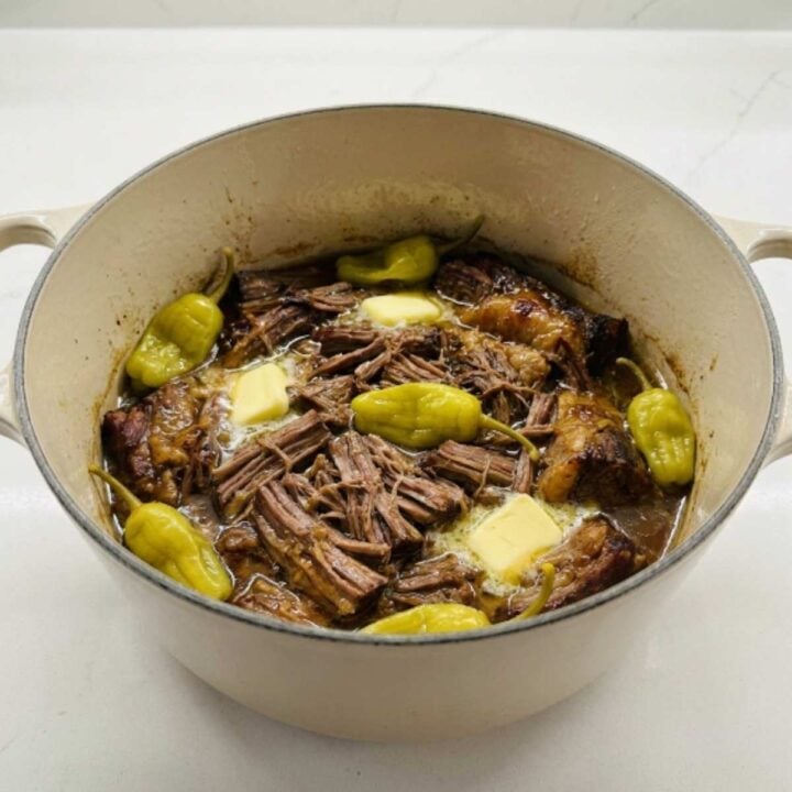 mississippi pot roast in a dutch oven with pepperoncini and butter